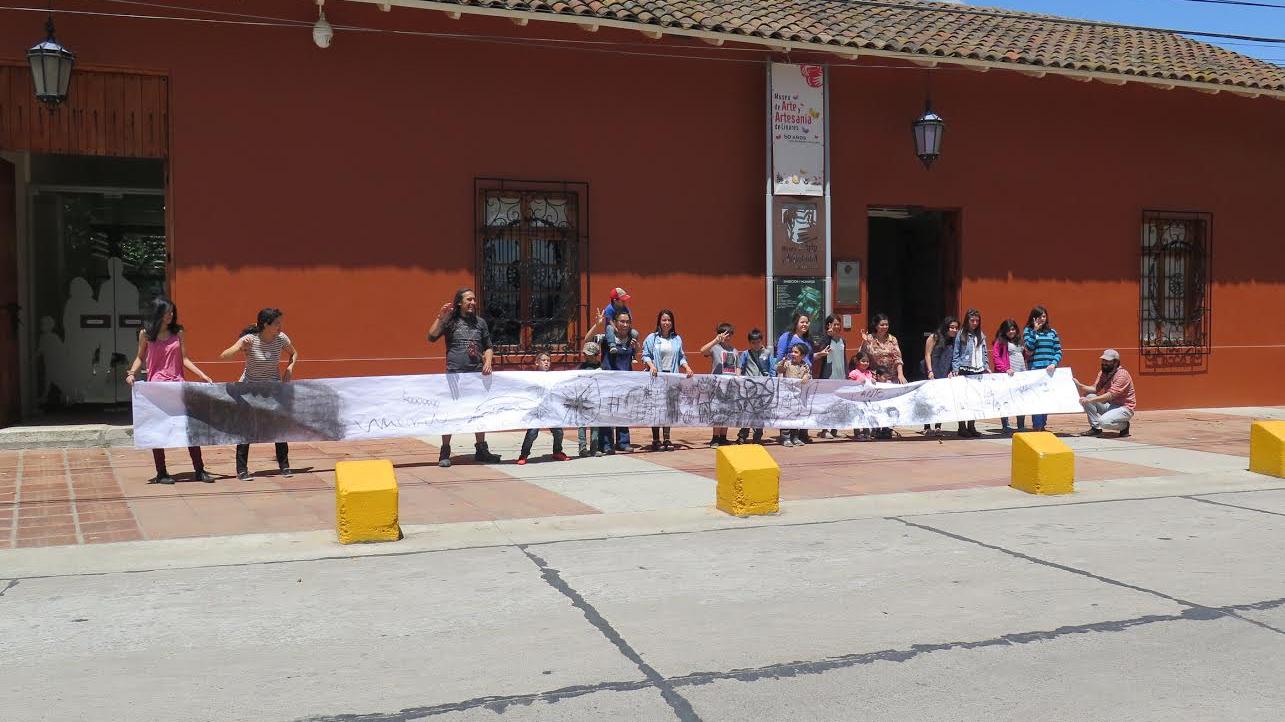 Presentación de lienzo intervenido por niños y niñas durante la jornada.